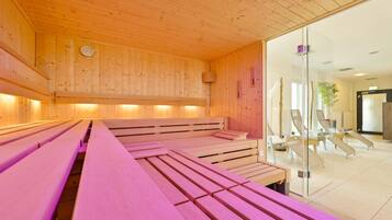 A sauna room with wooden benches and a glass wall.