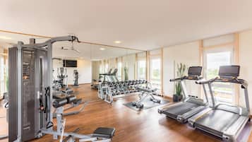 Ein Fitnessstudio mit Laufbändern, Kraftgeräten und Kurzhanteln.