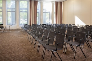 A conference room with rows of chairs, large windows with curtains, and a carpeted floor. - Best Western Plus Hotel Köln City (Cologne)