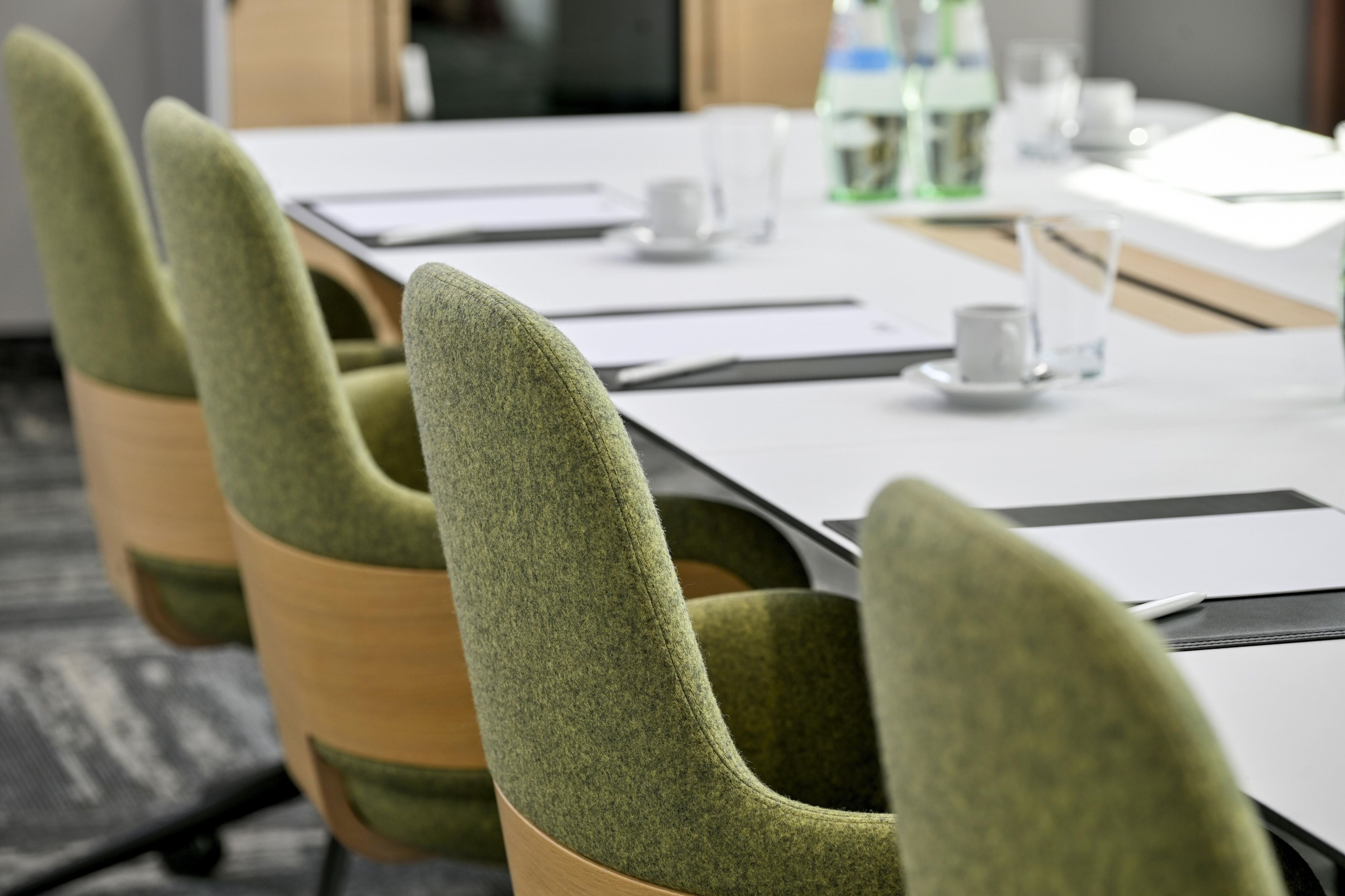 A conference room with a long table, chairs, and a water bottle on the table.