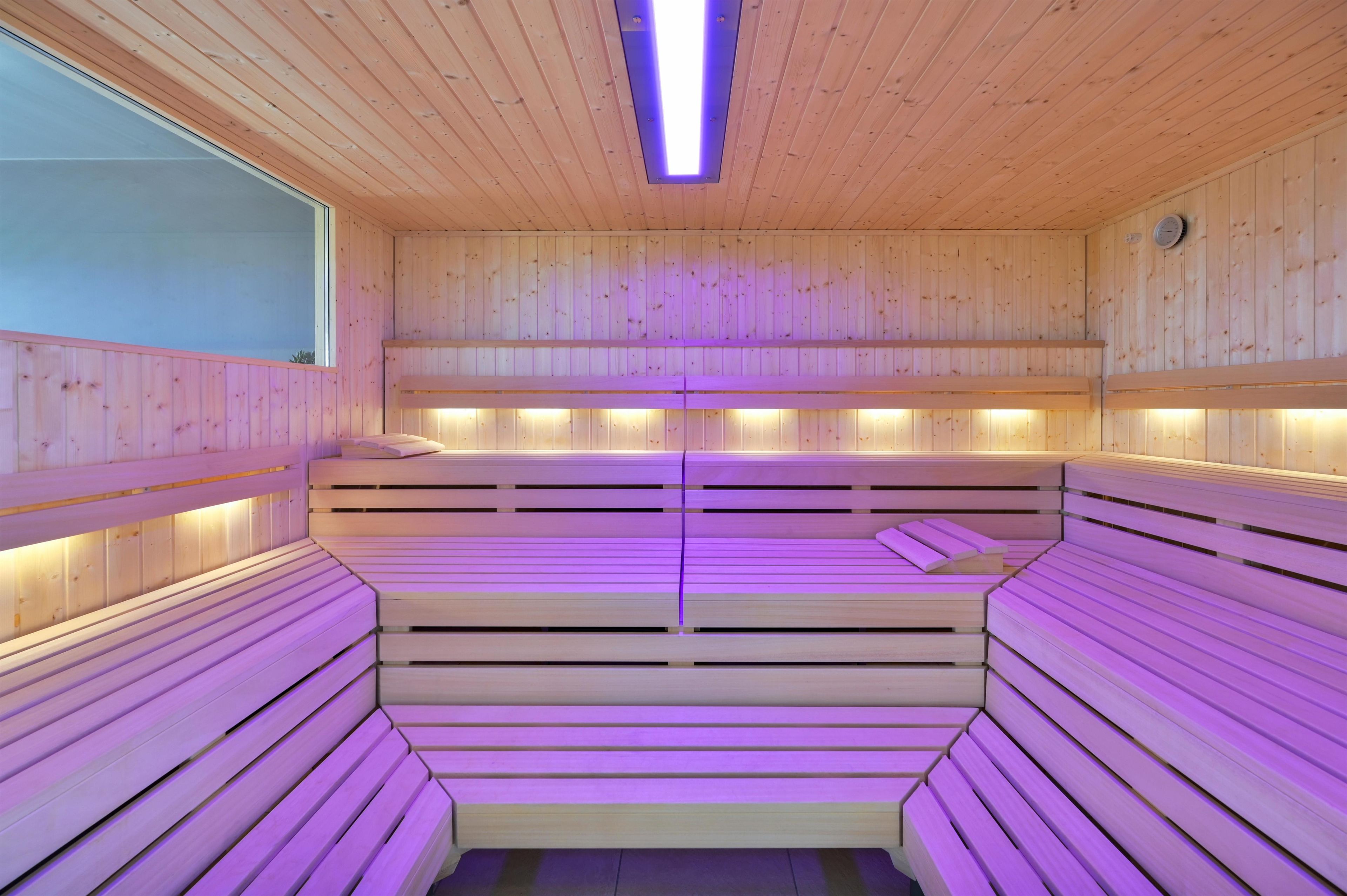 Una sauna con bancos de madera y techo inclinado.