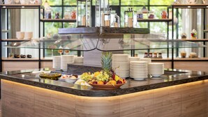 Ein reichhaltiges Buffet mit verschiedenen Früchten und einer Glastheke im Hintergrund.