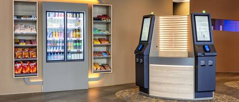 A kiosk with a self-service beverage dispenser and a payment terminal.