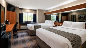 A hotel room with two beds, a desk with a computer, a TV, and a window with curtains. - Microtel Inn & Suites by Wyndham Bozeman (Bozeman)