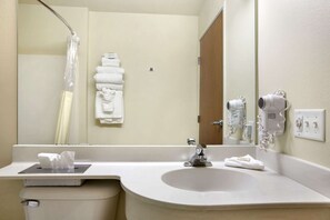 A bathroom with a sink, mirror, towel rack, and hair dryer. - Microtel Inn & Suites by Wyndham Bozeman (Bozeman)