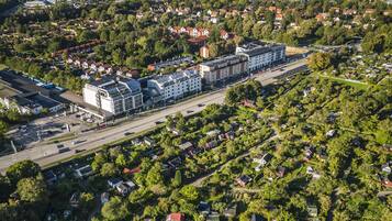 Vista aérea de una zona residencial con un gran complejo de edificios, rodeado de casas y vegetación.