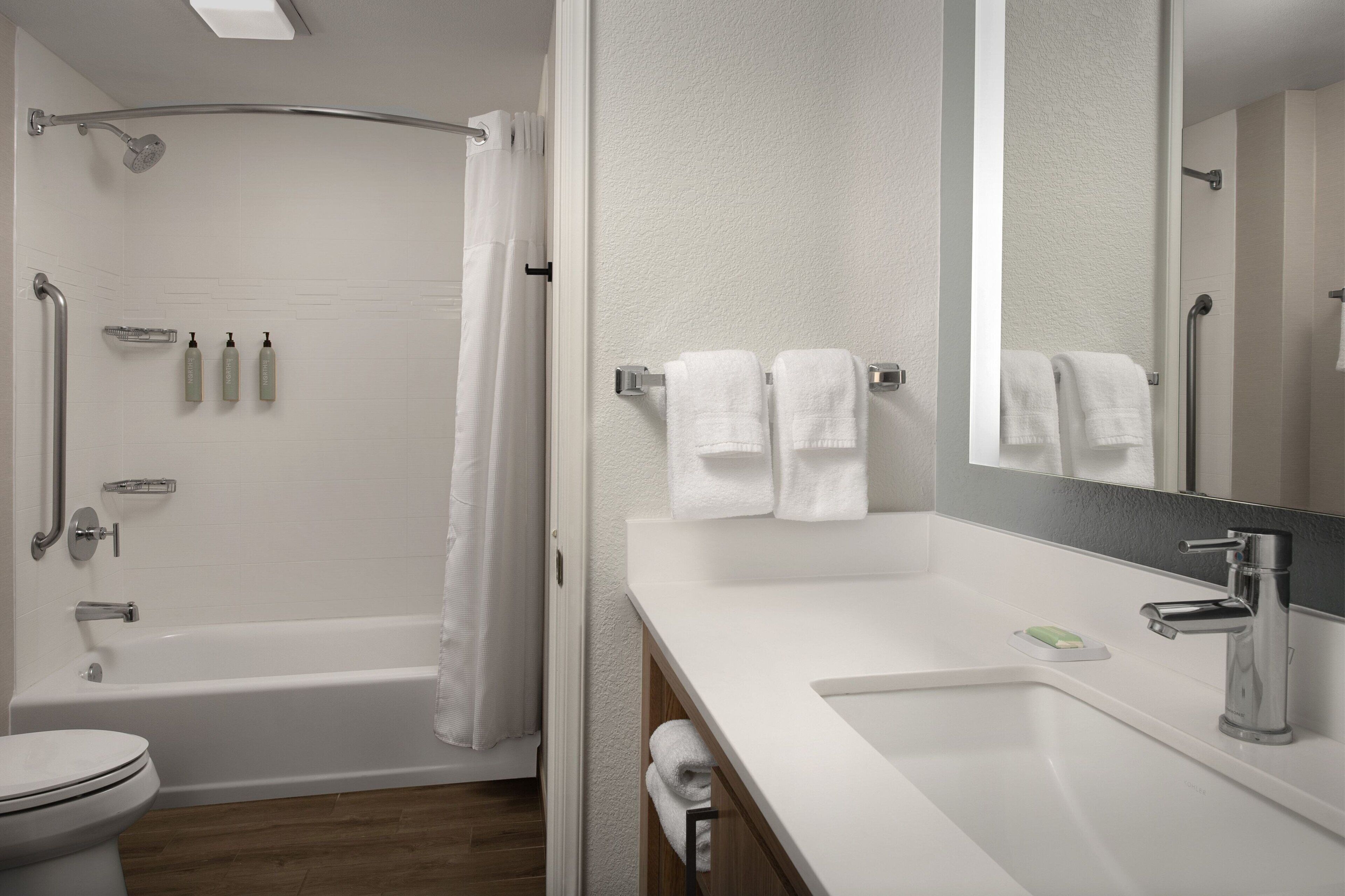 Une salle de bain moderne équipée d’une baignoire, de toilettes et d’un lavabo.