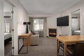 A hotel room with a bed, a sofa, a TV, a fireplace, and a dining table. - Residence Inn Marriott Palo Alto Los Altos (Los Altos)