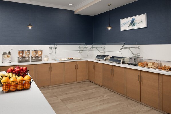 A modern kitchen with wooden cabinets, a white countertop, and various breakfast items. - Residence Inn Marriott Palo Alto Los Altos (Los Altos)