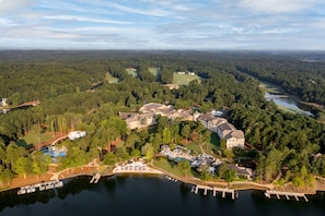 An aerial view of a resort with multiple buildings, a lake, and a golf course.