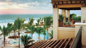 Un resort con piscina, palmeras y vistas al océano.