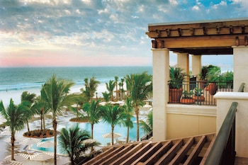 A spacious dining area with a large island, white cabinetry, and a view of the ocean. at The Ritz-Carlton, Sarasota