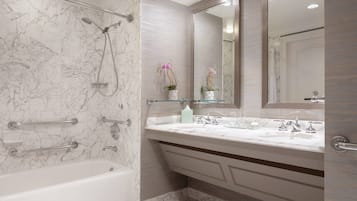 Un baño con bañera, ducha, tocador con espejo y retrete.