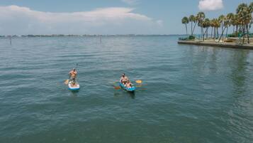 Dos personas remando en un canoa azul sobre aguas tranquilas.