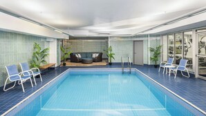 A swimming pool with lounge chairs and a sofa area. - Four Points by Sheraton Halifax (Halifax)