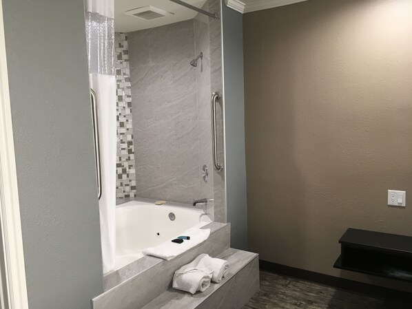 A modern bathroom with a walk-in shower, a built-in bathtub, and a vanity with a mirror.