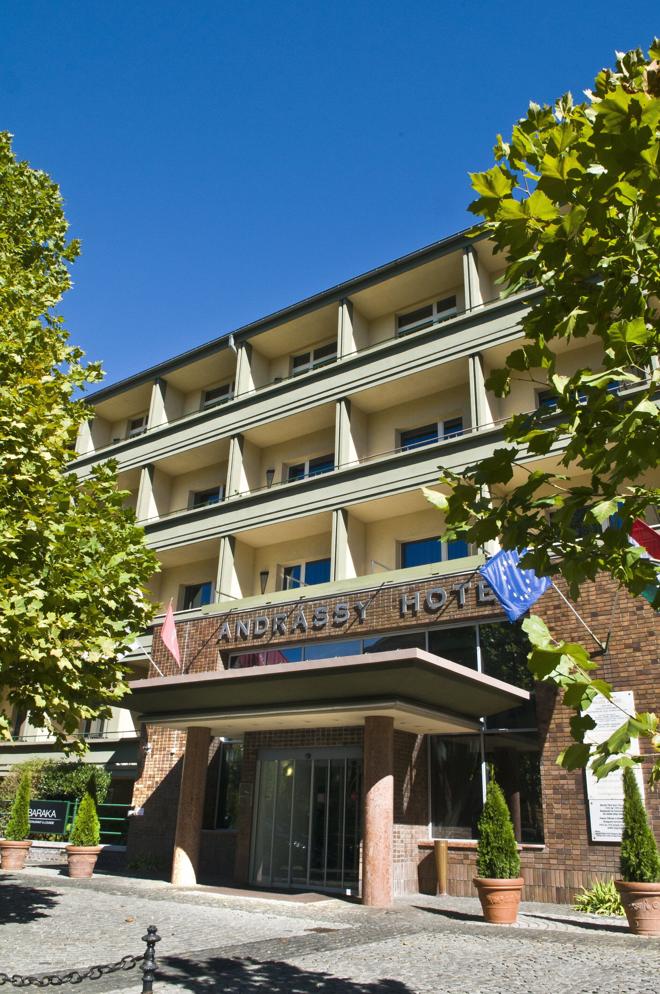 Un hotel de varios pisos con un cartel llamativo que dice "ANDRASY HOTEL".