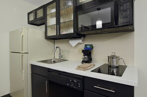 A modern kitchen with a refrigerator, dishwasher, microwave, stove, and sink. - Candlewood Suites Rogers / Bentonville by IHG (Rogers)