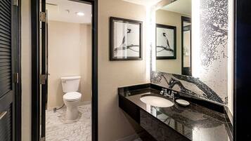 Une salle de bain moderne avec des toilettes, un lavabo et un grand miroir.