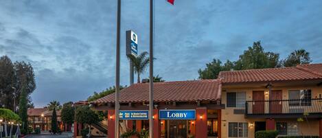 A hotel lobby with a sign reading "Lobby" and a sign for a free in-room coffee, spa, and refrigerator.