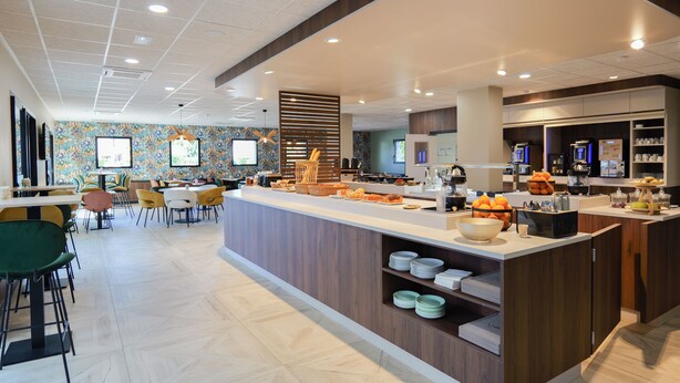 A modern kitchen area with a central island, bar area, and seating space.