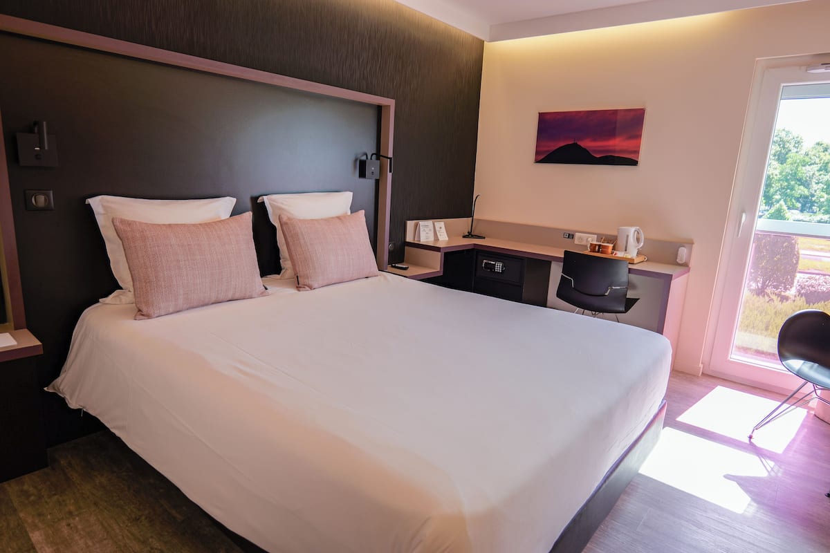 Een hotelkamer met een groot bed, een bureau en een stoel.