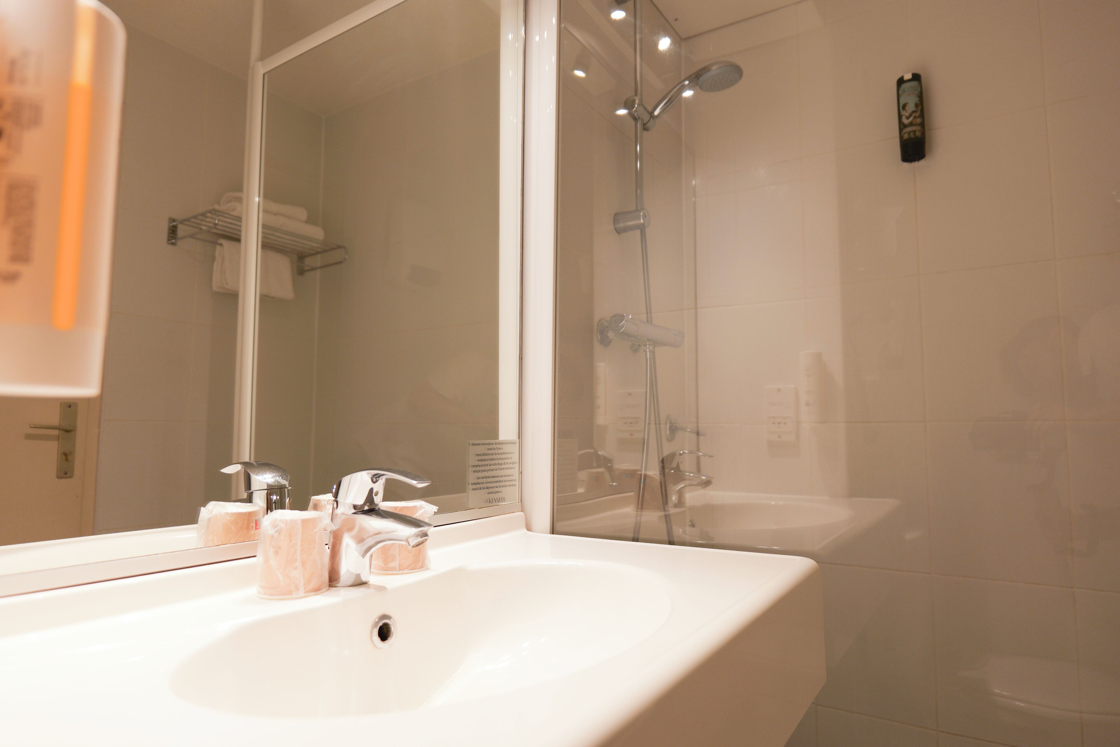 A bathroom with a white sink, a mirror, and a shower.