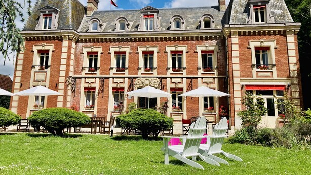 A historic building with a symmetrical facade, multiple windows, and a flag. - Château Corneille (Le Val d'Hazey)