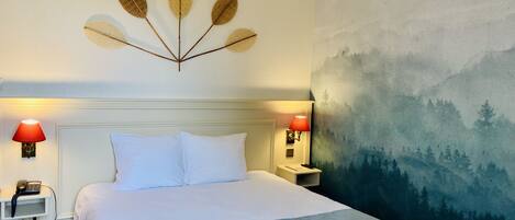 A neatly made bed with white linens, a headboard, and a wall-mounted decorative leaf arrangement.