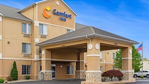 A Comfort Inn hotel with a beige exterior, a covered entrance, and an American flag. - Comfort Inn Henderson - Evansville South (Henderson)