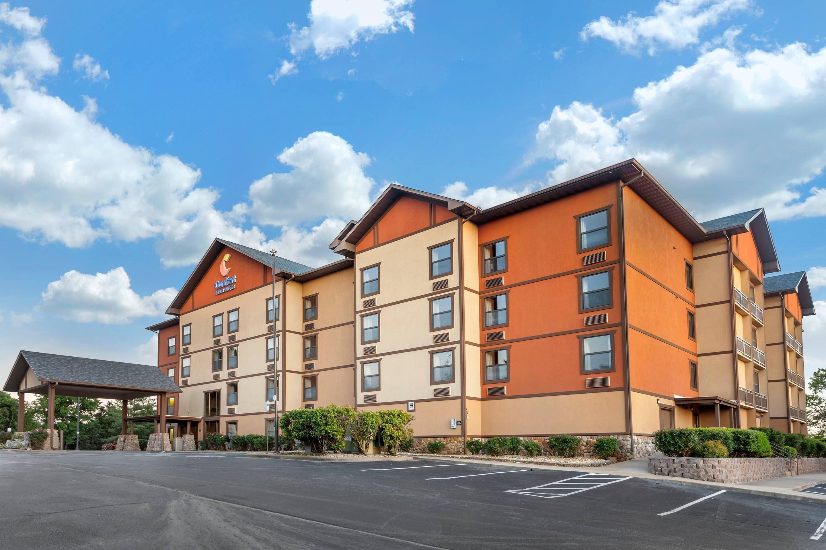 A multi-story hotel with a flat roof, large windows, and a covered entrance.