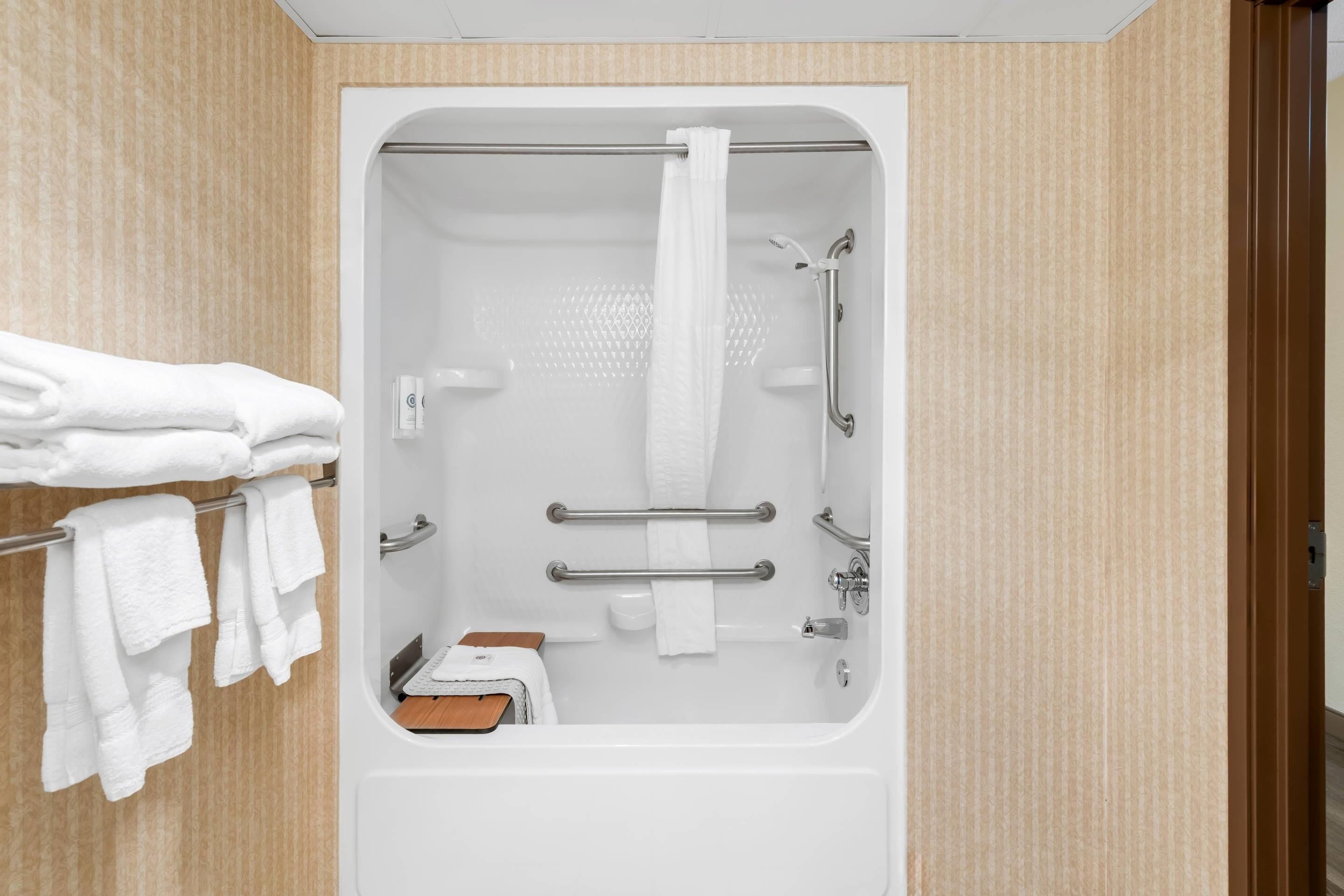 A bathroom with a bathtub, a shower, and a toilet. There are towels hanging on a rack.