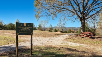 A sign for a walking trail with a clear sky and trees in the background.