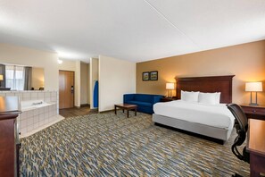 Hotellihuone, jossa on sänky, työpöytä, tuoli, sohva ja kylpyhuone.