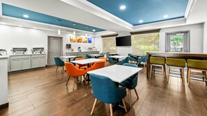 Una cocina moderna con armarios blancos, encimera de madera y techo azul.