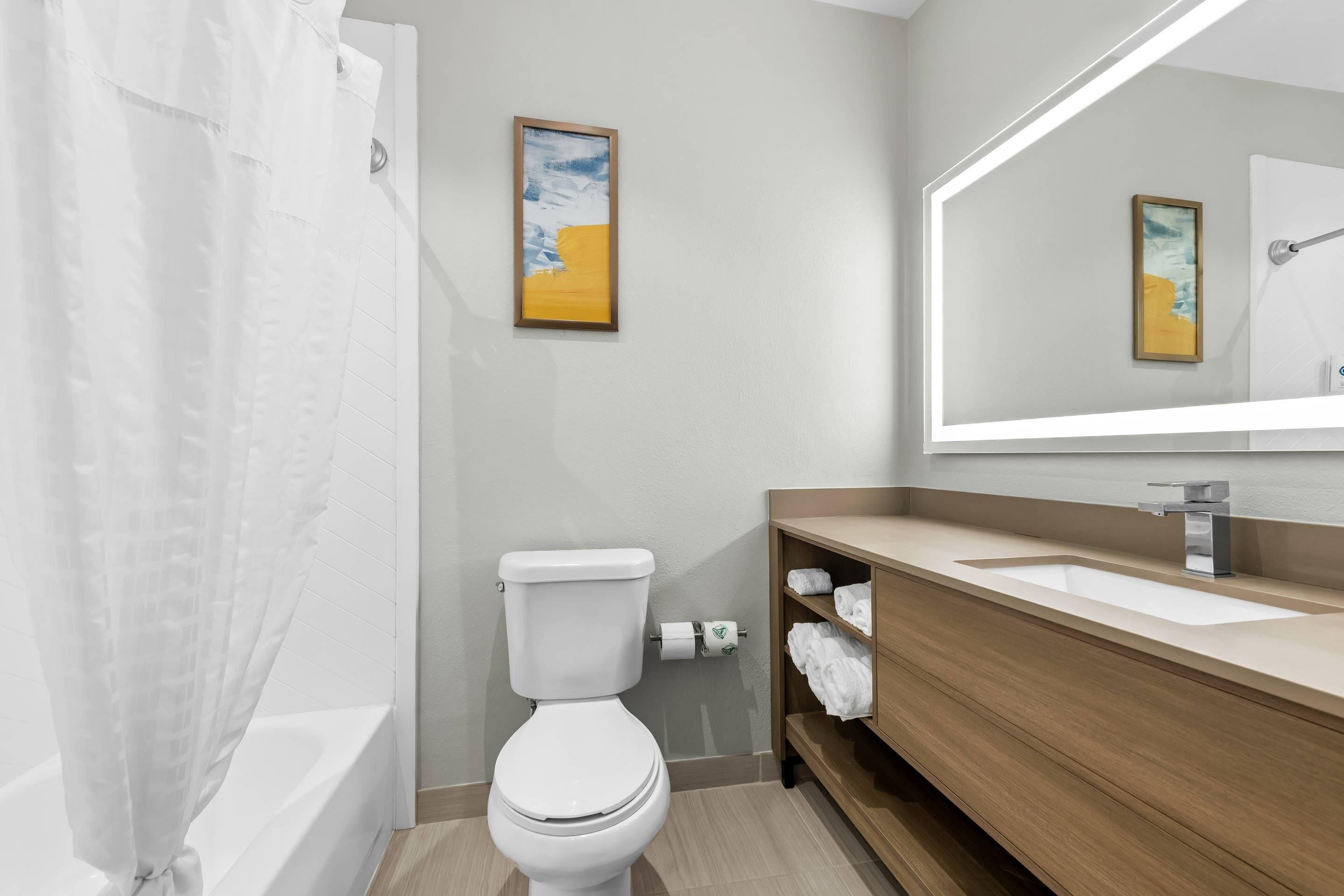 A modern bathroom with a bathtub, toilet, and sink.
