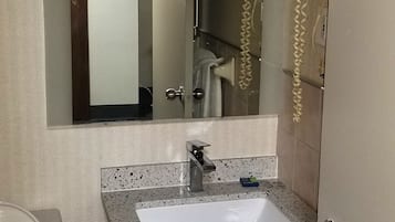 A bathroom with a white sink, a mirror, a hairdryer, and a toilet.