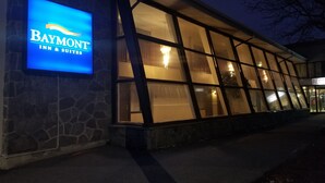 A building with a large illuminated sign reading "Baymont Inn & Suites."