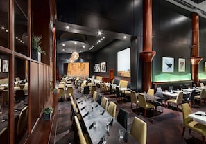 A spacious restaurant with long tables, high ceilings, and modern decor. - Hilton Lac-Leamy (Gatineau)