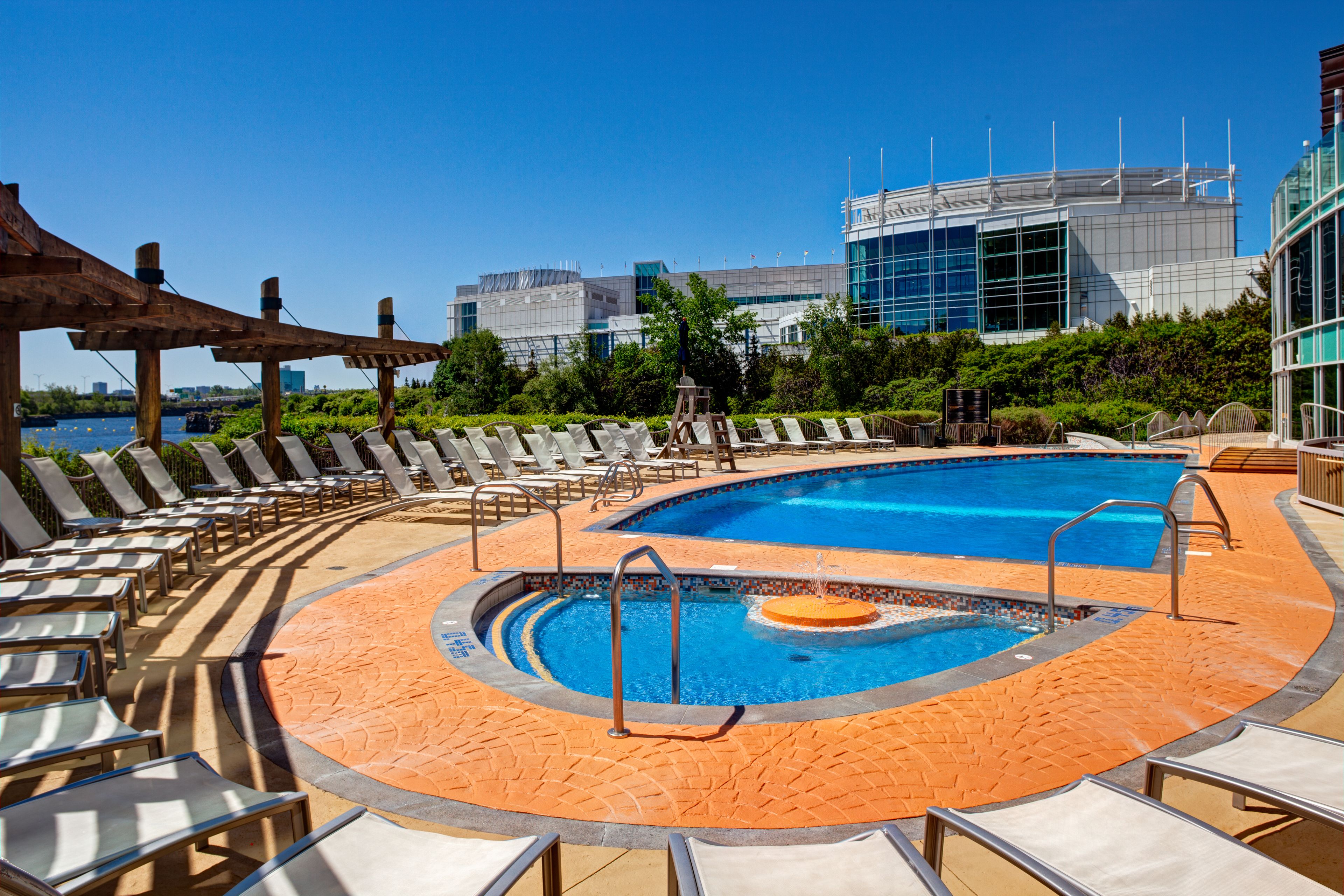 Un espace piscine avec des chaises longues et une fontaine.