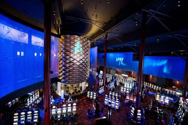 A casino with multiple gaming tables and a large, illuminated cylindrical structure.