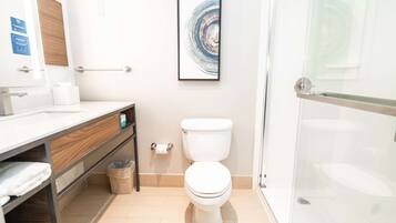 Un baño moderno con inodoro, lavamanos y ducha.