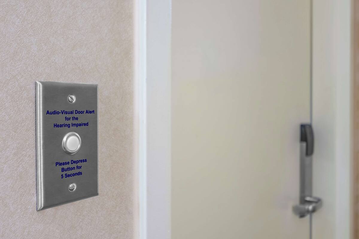 A door with an audio-visual alert system for the hearing impaired, including a depress button for 5 seconds.