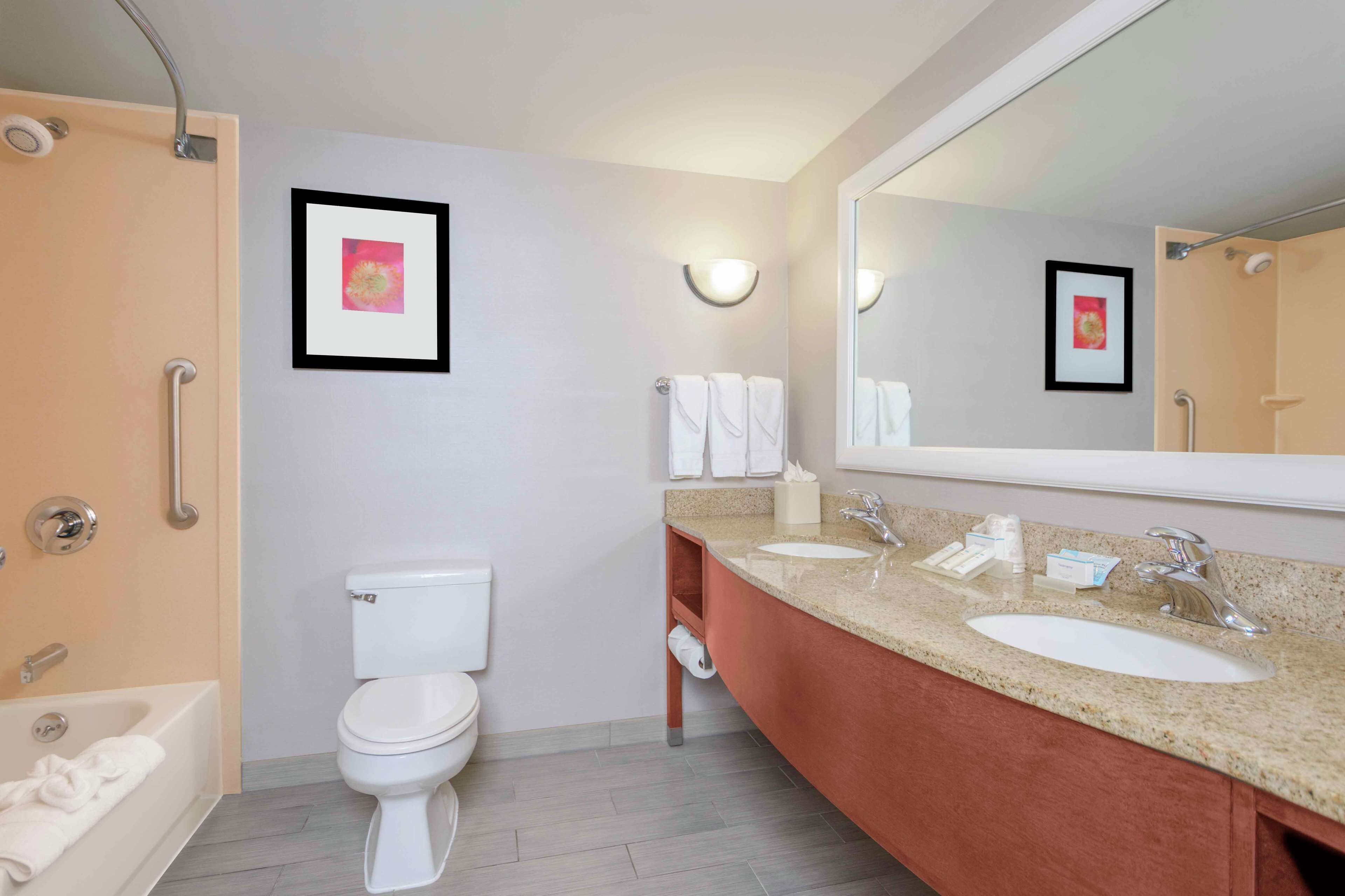 Un baño moderno con bañera, inodoro y doble lavamanos.