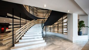 A modern staircase with wooden steps and metal railings, leading to a second floor. - Hotel Riazor (A Coruña)