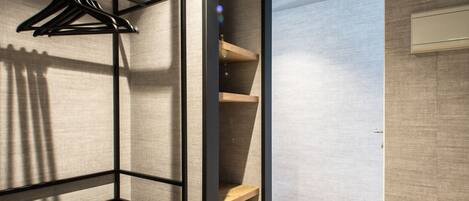Habitación moderna y compacta con cama integrada, suelo de madera y estantería montada en la pared.