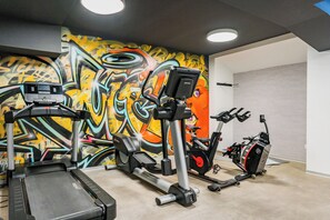 A gym with a stationary bike, elliptical, and treadmill.