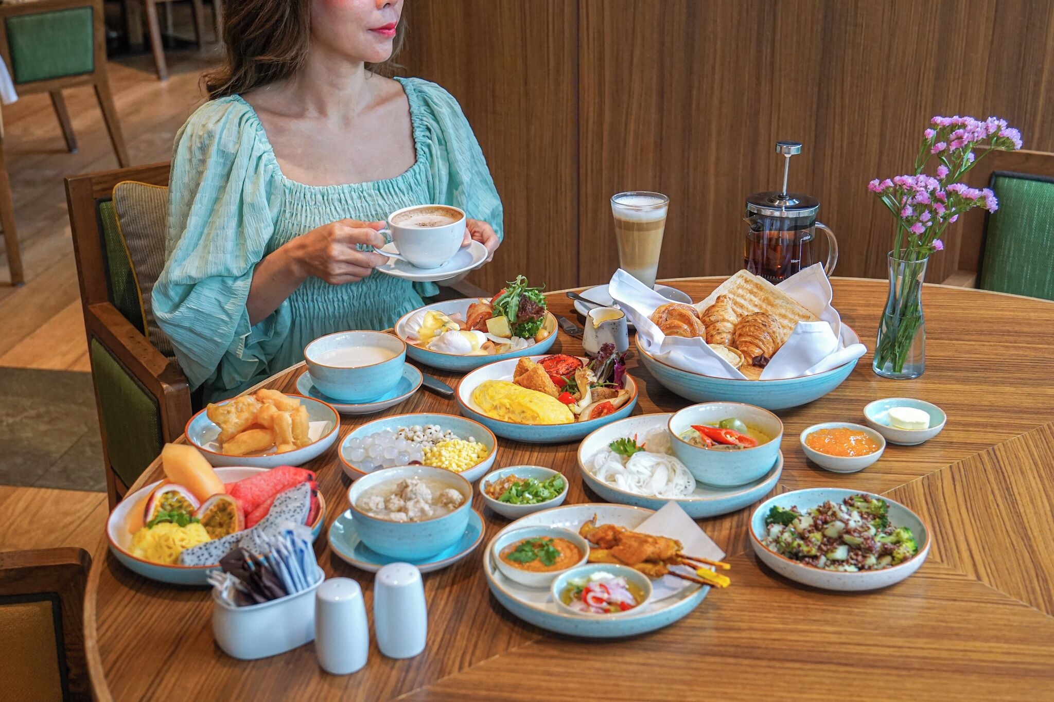A dining table with various dishes, a coffee cup, and a pitcher of iced coffee.