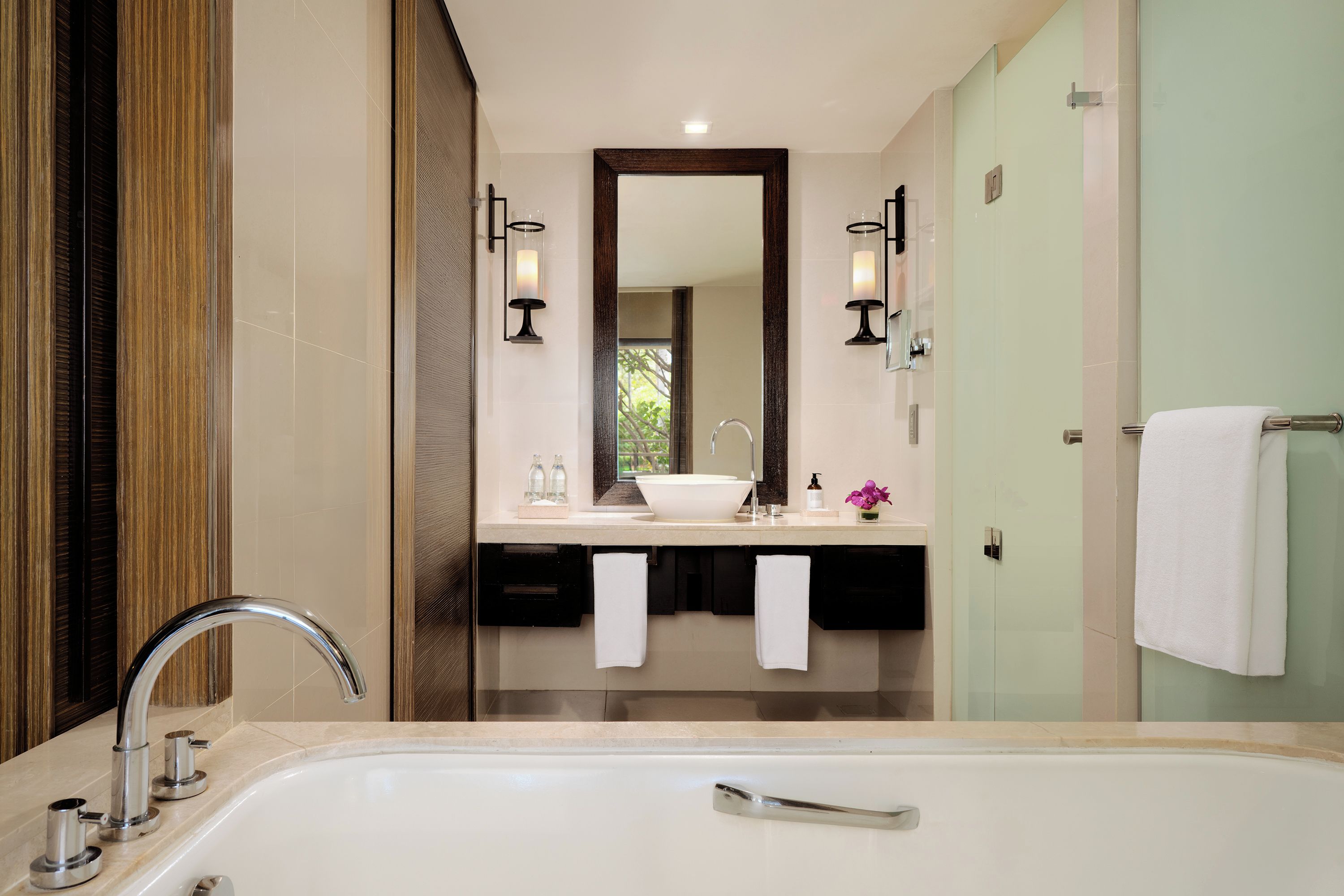A modern bathroom with a large bathtub, a double sink vanity, and a mirror above the sink.