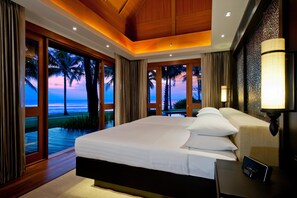 A hotel room with a large bed, a bedside table, a lamp, and a view of the ocean. - Hyatt Regency Hua Hin (Hua Hin)